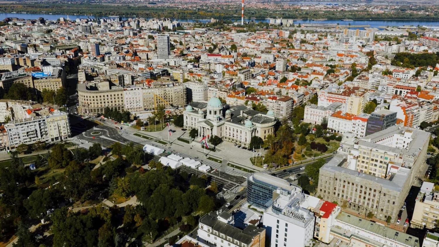 Luftaufnahme von Belgrad mit Präsidentenpalast, umliegenden historischen Gebäuden, Donau im Hintergrund und städtischem Parklandschaft
