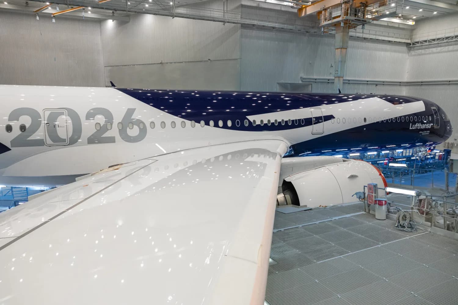 Lufthansa Airbus A350 im Hangar mit Flügel- und Triebwerksansicht, Sonderlackierung mit großer „2026“-Beschriftung und dunkelblauem Rumpfdesign