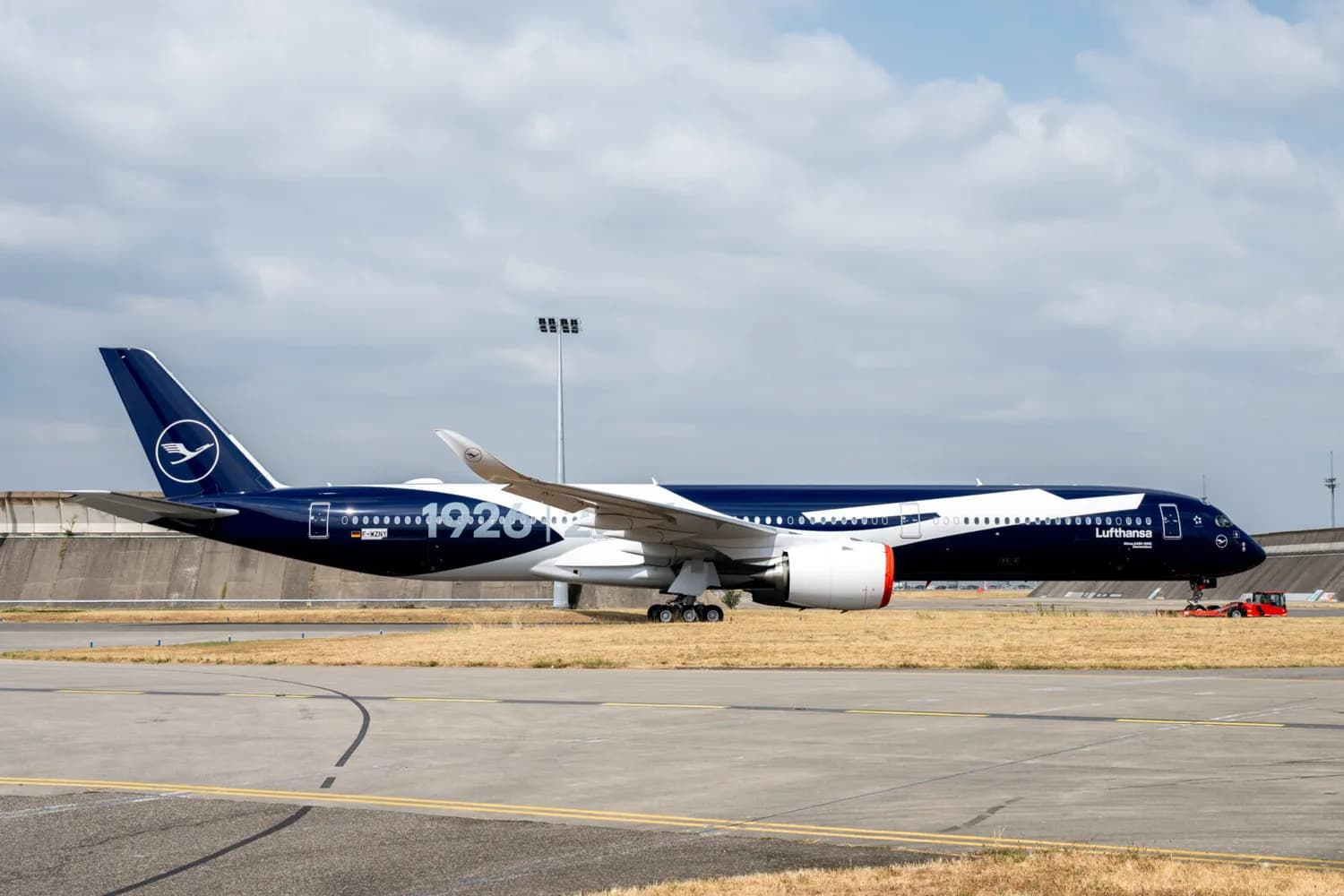 Lufthansa A350-1000 in dunkelblauer Sonderlackierung auf dem Rollfeld beim Rollout, Seitenansicht mit sichtbarem Logo und Fahrwerk