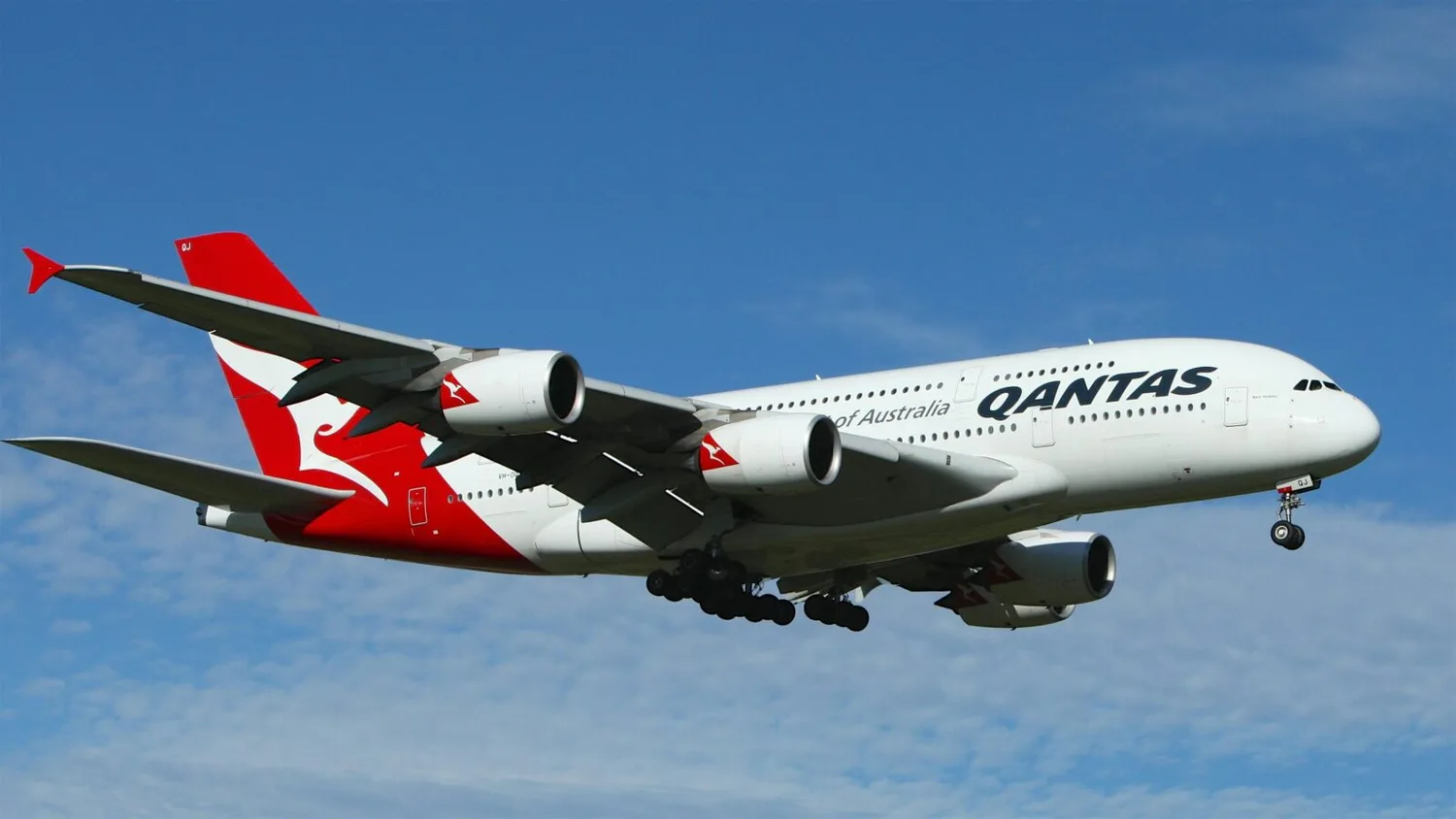 Qantas Airbus A380 im Landeanflug mit ausgefahrenem Fahrwerk vor blauem Himmel