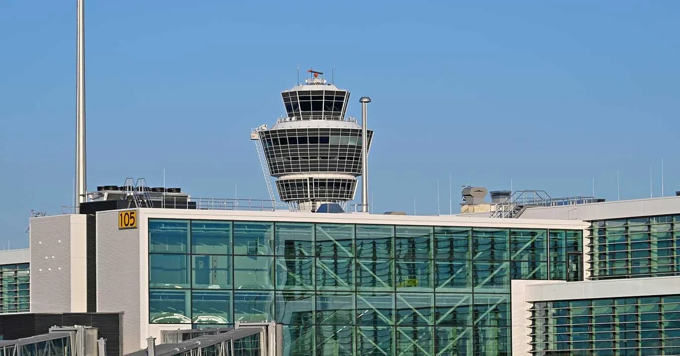 Kontrollturm hinter neuem Glas-Flughsteig des Terminals am Flughafen München