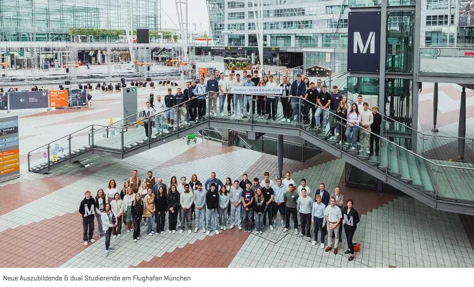 Gruppenfoto von Auszubildenden und dual Studierenden am Flughafen München auf Treppe und Vorplatz mit Beschilderung ParkSleepFly