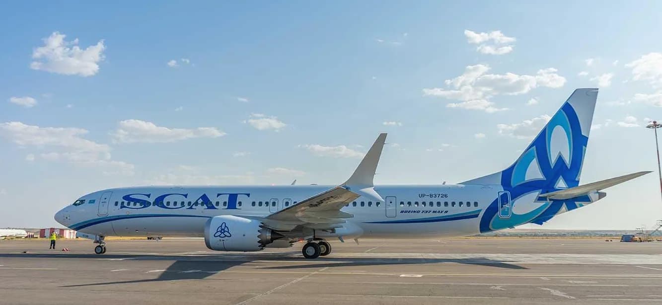 SCAT Airways Boeing 737 MAX am Flughafen München auf dem Vorfeld geparkt, Seitenansicht mit markantem blau-türkis Logo und Triebwerk