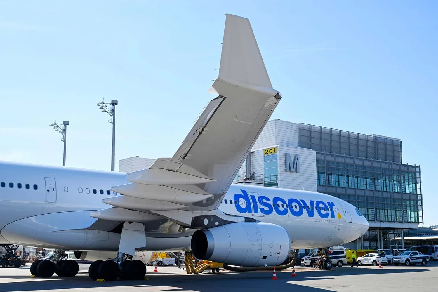 Discover Airlines Passagierflugzeug am Gate mit sichtbarem Heck, Triebwerk und Flügeln auf dem Flughafenvorfeld