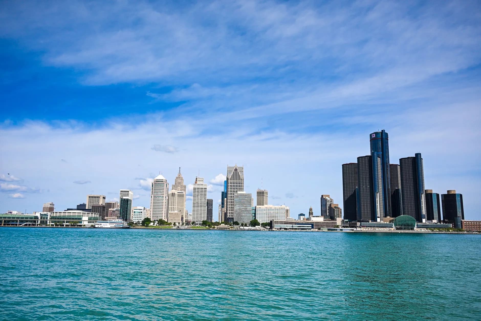 Skyline von Detroit mit Hochhäusern am Ufer des Flusses bei blauem Himmel
