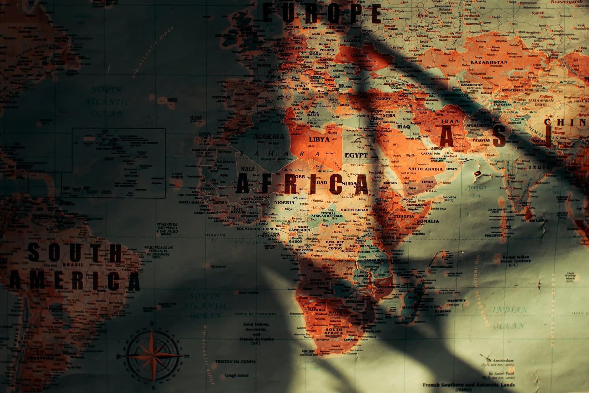Weltkarte mit Europa, Afrika und Asien, überzogen von Schatten und warmem Lichteinfall