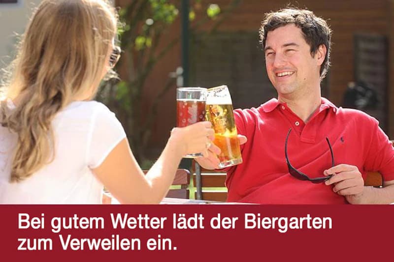 Zwei Personen stoßen im sonnigen Außenbereich mit Biergläsern an; rote Textleiste unten.